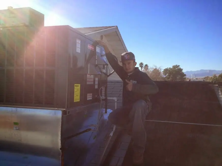 HVAC technician performing Air Duct Cleaning on a rooftop unit in Orangeburg